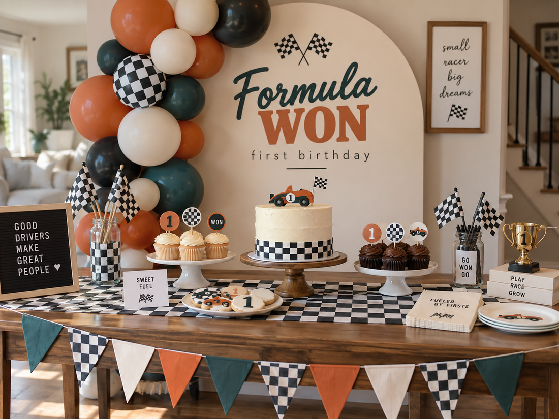 Retro Formula WON first birthday party setup with a terracotta orange, deep teal, and cream balloon garland, checkered table runner, race car cake, cupcakes, cookies, and simple racing decor styled for an achievable at home celebration.