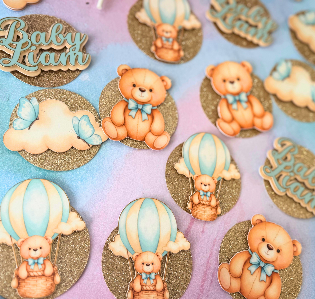 Champaign Glitter Layered Baby Shower cupcake toppers with teddy bears, hot air balloons, and 'Baby Liam' text on a colorful background.