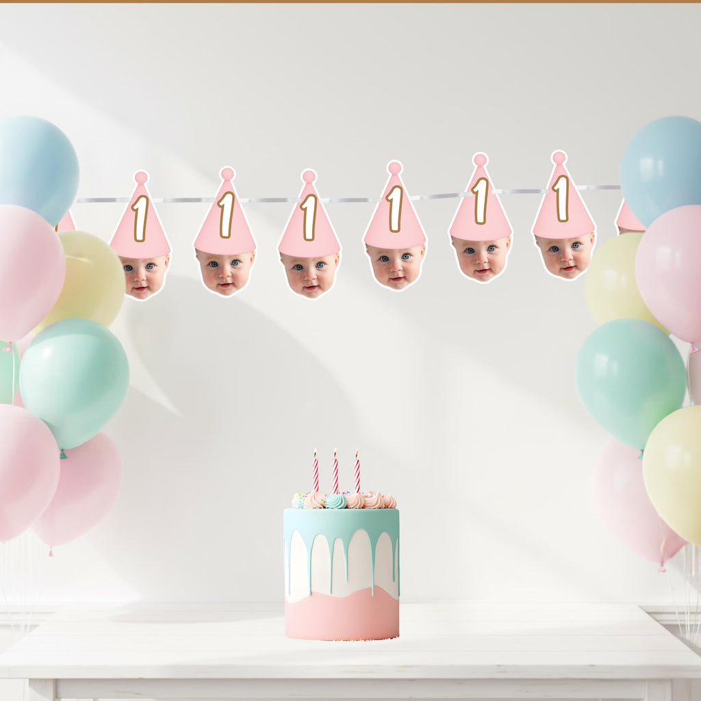 Birthday cake with candles, balloons, and baby faces in hats on a white background