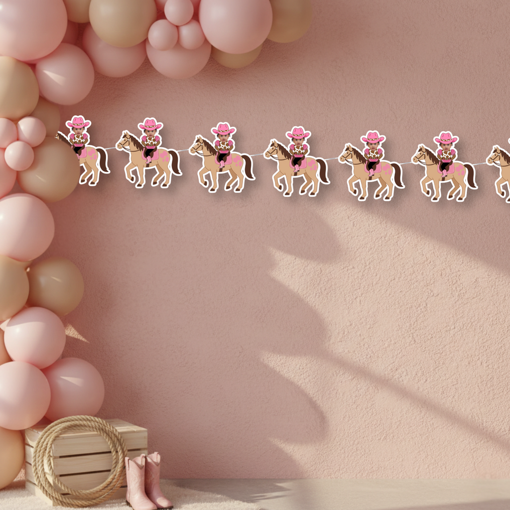 Cowgirl smash cake backdrop featuring personalized My First Rodeo photo banner on blush textured wall with western party accents. This elegant pink cowgirl birthday setup highlights the custom photo banner as a statement piece for smash cake photos and little rodeo celebrations.