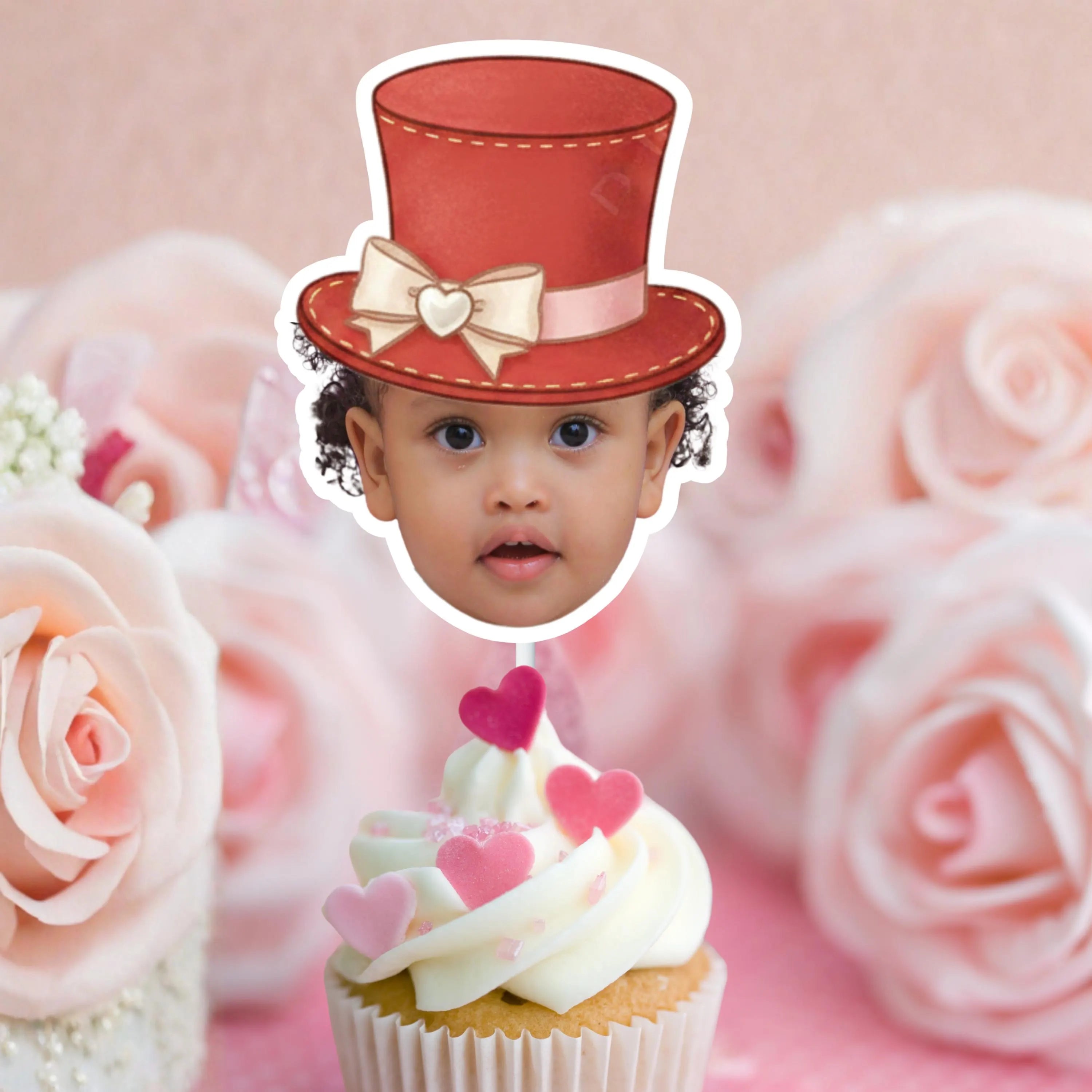 Child's face on a cupcake with pink roses in the background