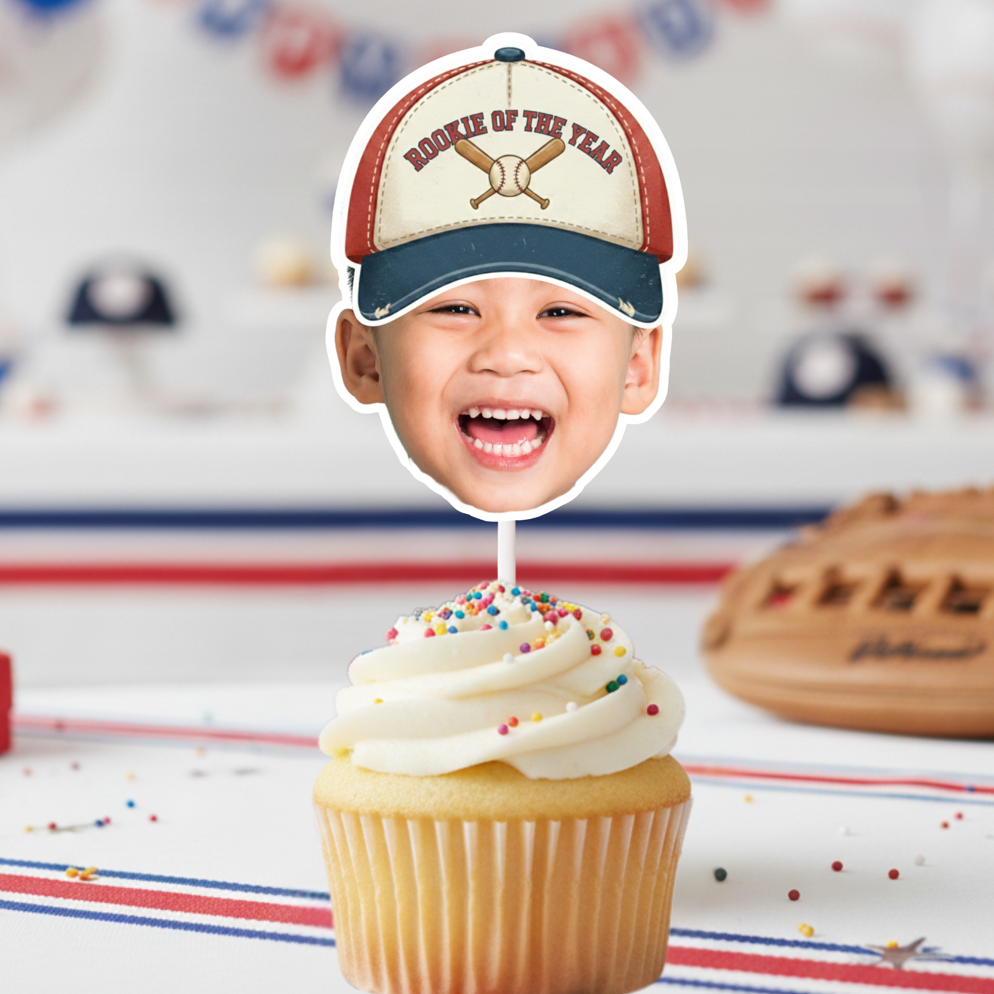 Baseball birthday face cupcake topper with smiling child photo wearing Rookie of the Year hat on sprinkle cupcake, styled with baseball glove and sports decor, perfect for baseball birthday party supplies and little league celebration.