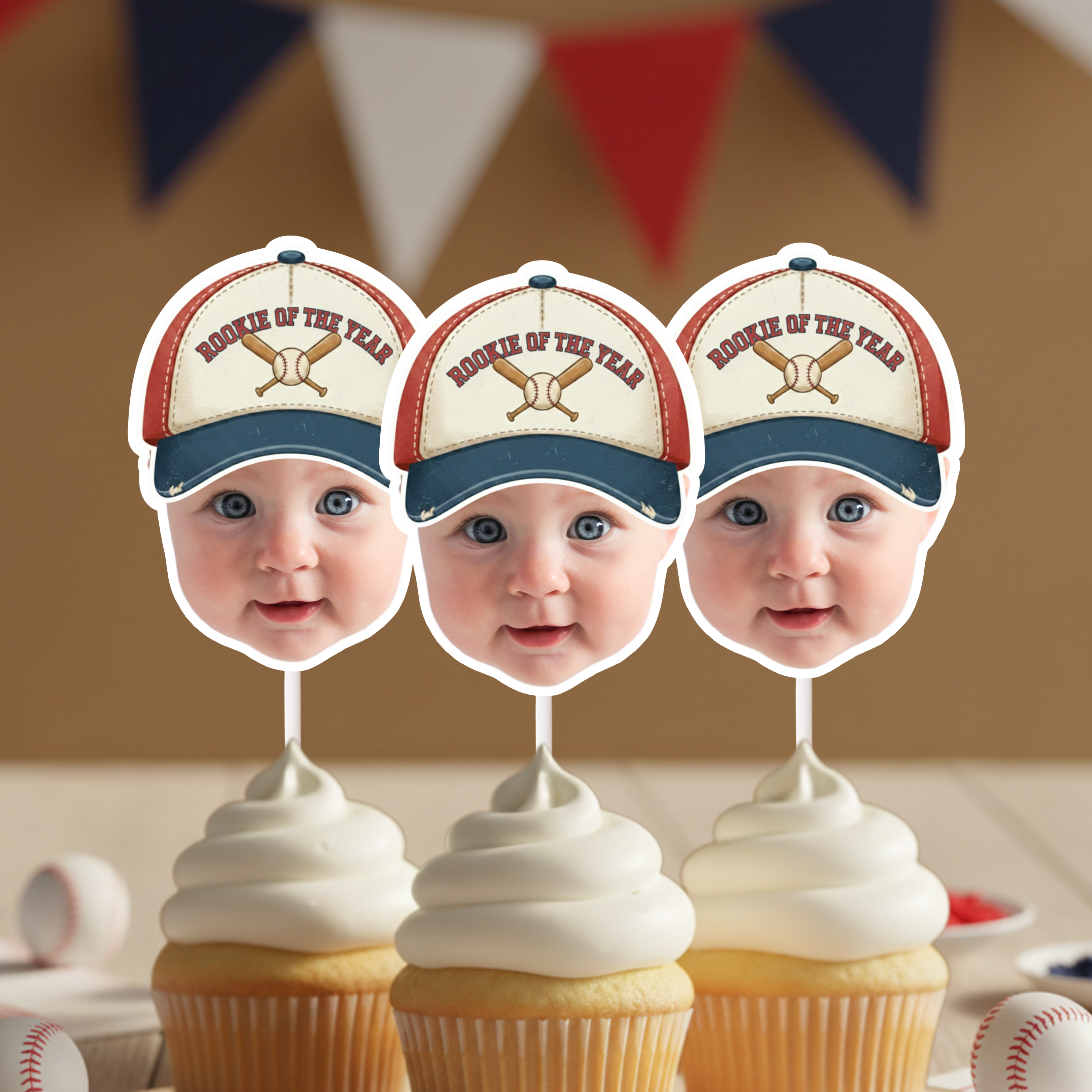 Set of three Rookie of the Year baseball baby face cupcake toppers displayed on frosted cupcakes with red white and blue bunting, ideal for baseball first birthday party decor, little slugger theme and sports themed dessert table styling.