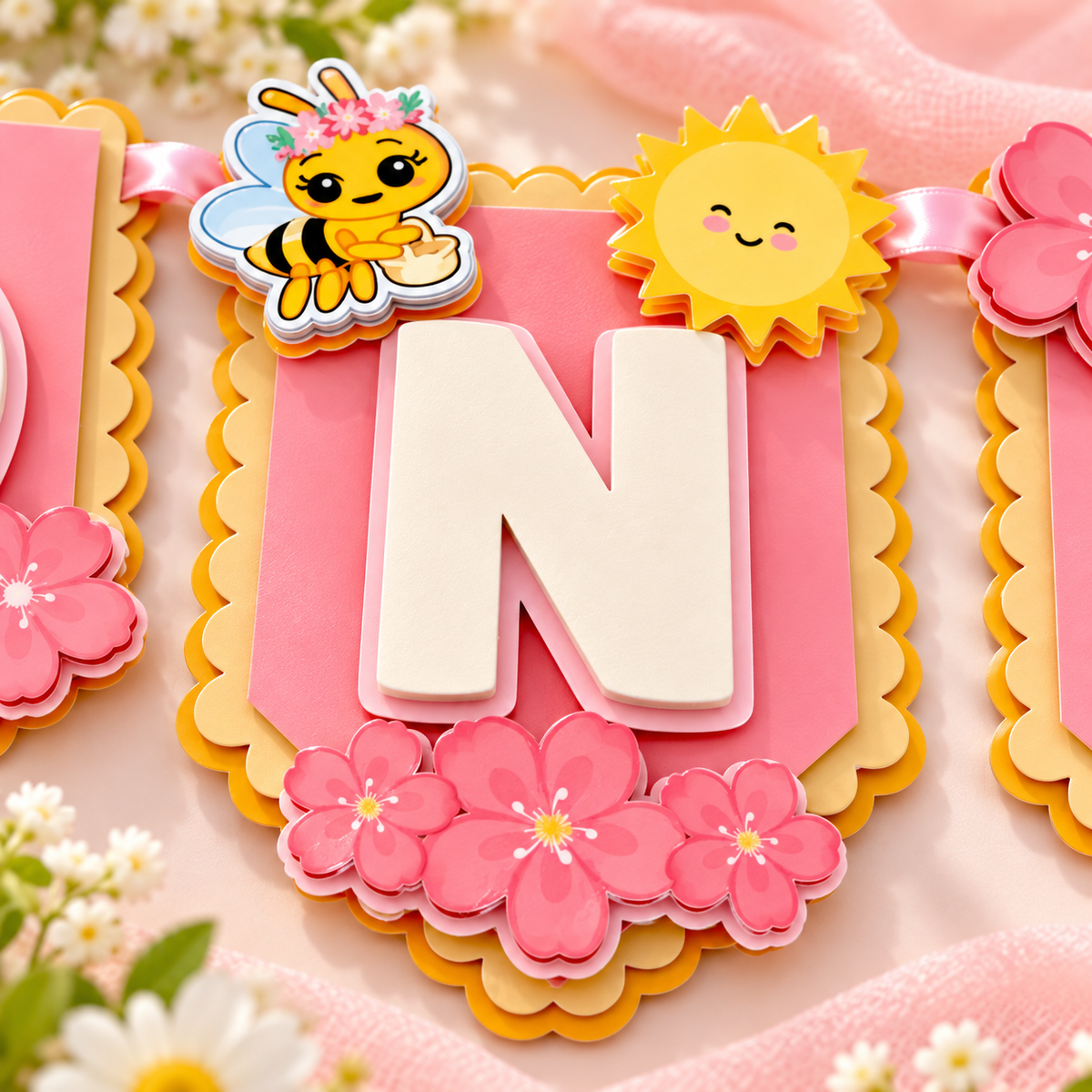 Close up of the center N panel from a Sweet One bee high chair banner with layered flowers, bee, sunshine, and dimensional cardstock details.