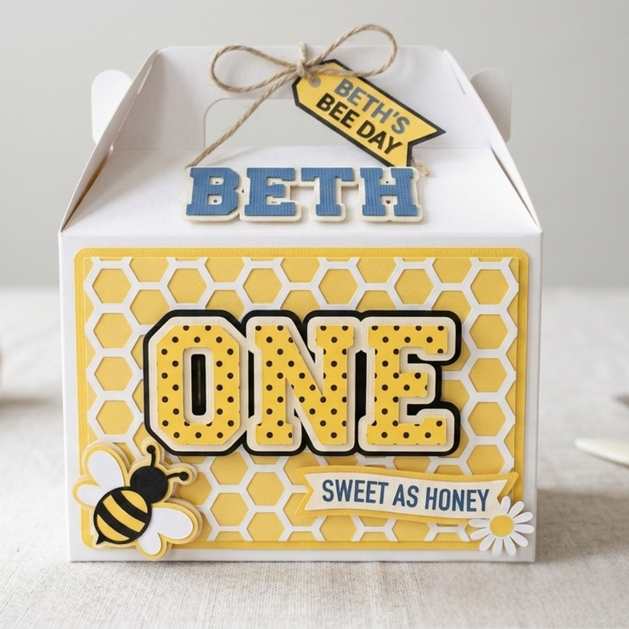 Custom Bee Day One birthday party favor box featuring honeycomb layered cardstock design, raised number one centerpiece, handmade bee decorations, and personalized first birthday favor packaging.
