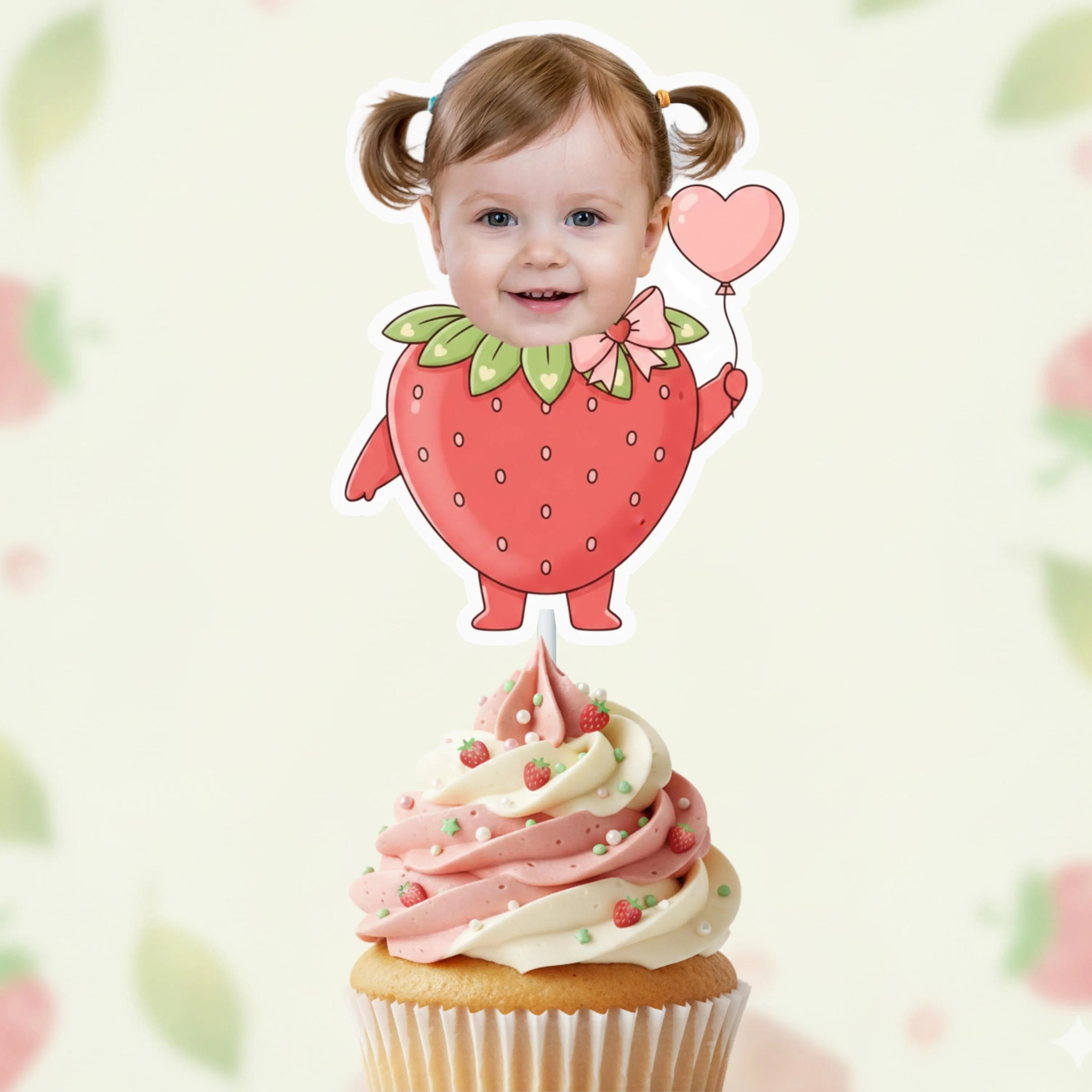 Child with a strawberry-themed cupcake topper on a blurred background