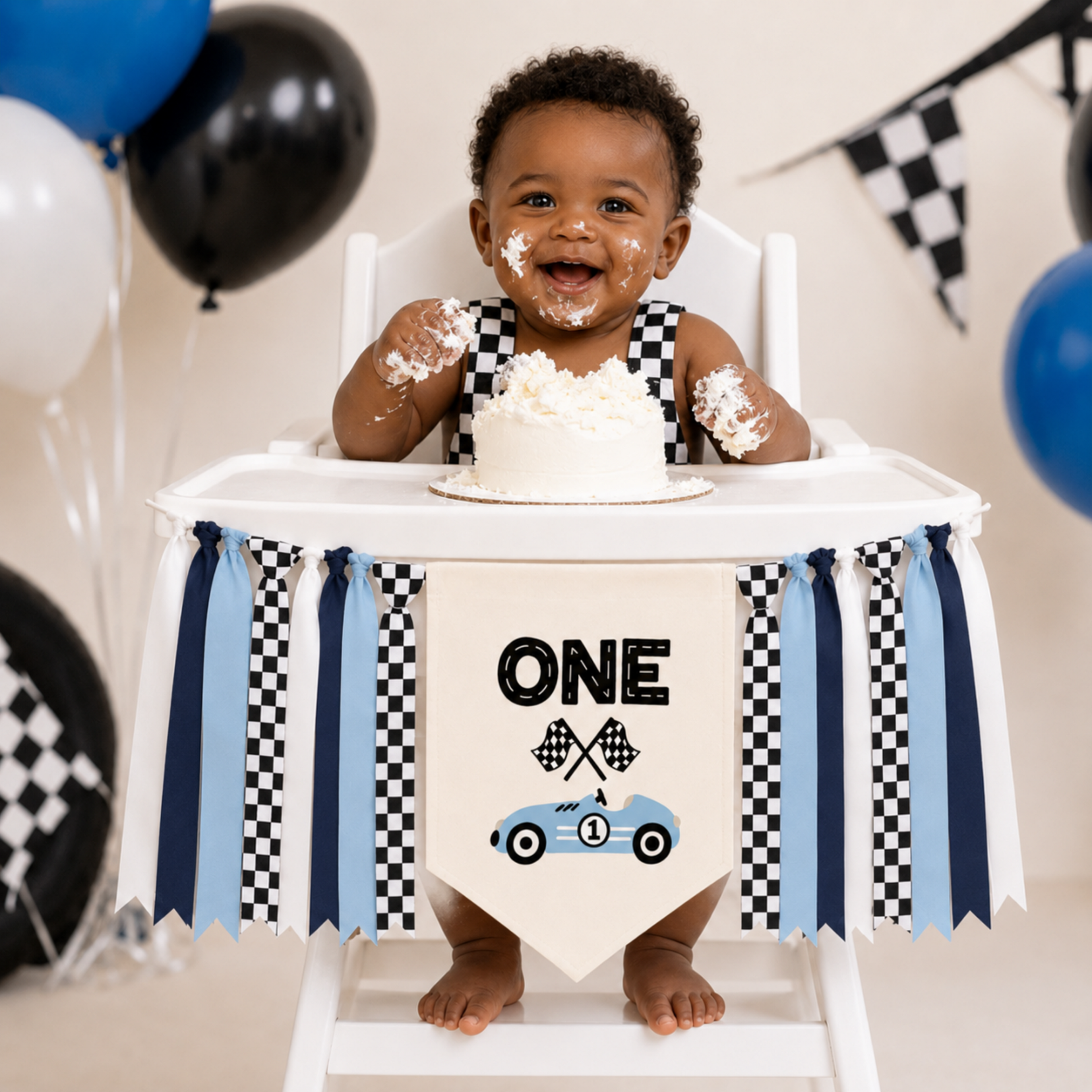 Blue race car highchair banner displayed during a first birthday cake smash featuring blue and checkered ribbon for a Fast One, Formula WON, speedway, Grand Prix, or race car themed birthday celebration.