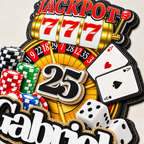 Closeup of a personalized casino birthday cake topper with age 25, jackpot slot machine, roulette wheel, poker chips, playing cards, dice and layered cardstock details.