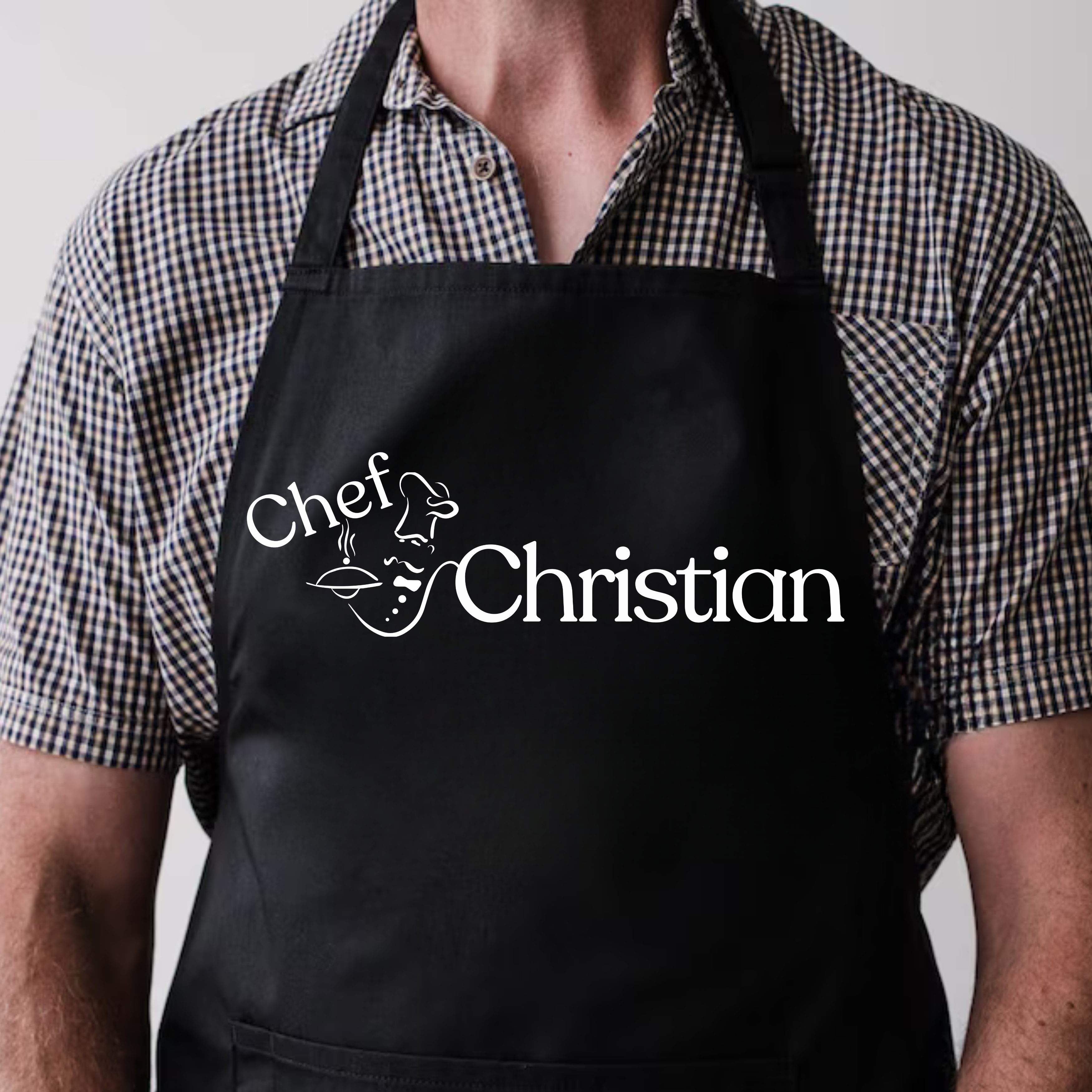 Person wearing a black apron with 'Chef Christian' printed on it.