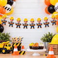 Personalized construction photo banner displayed above a construction birthday cake table with yellow orange and black balloons dump trucks cupcakes traffic cones and builder party decorations