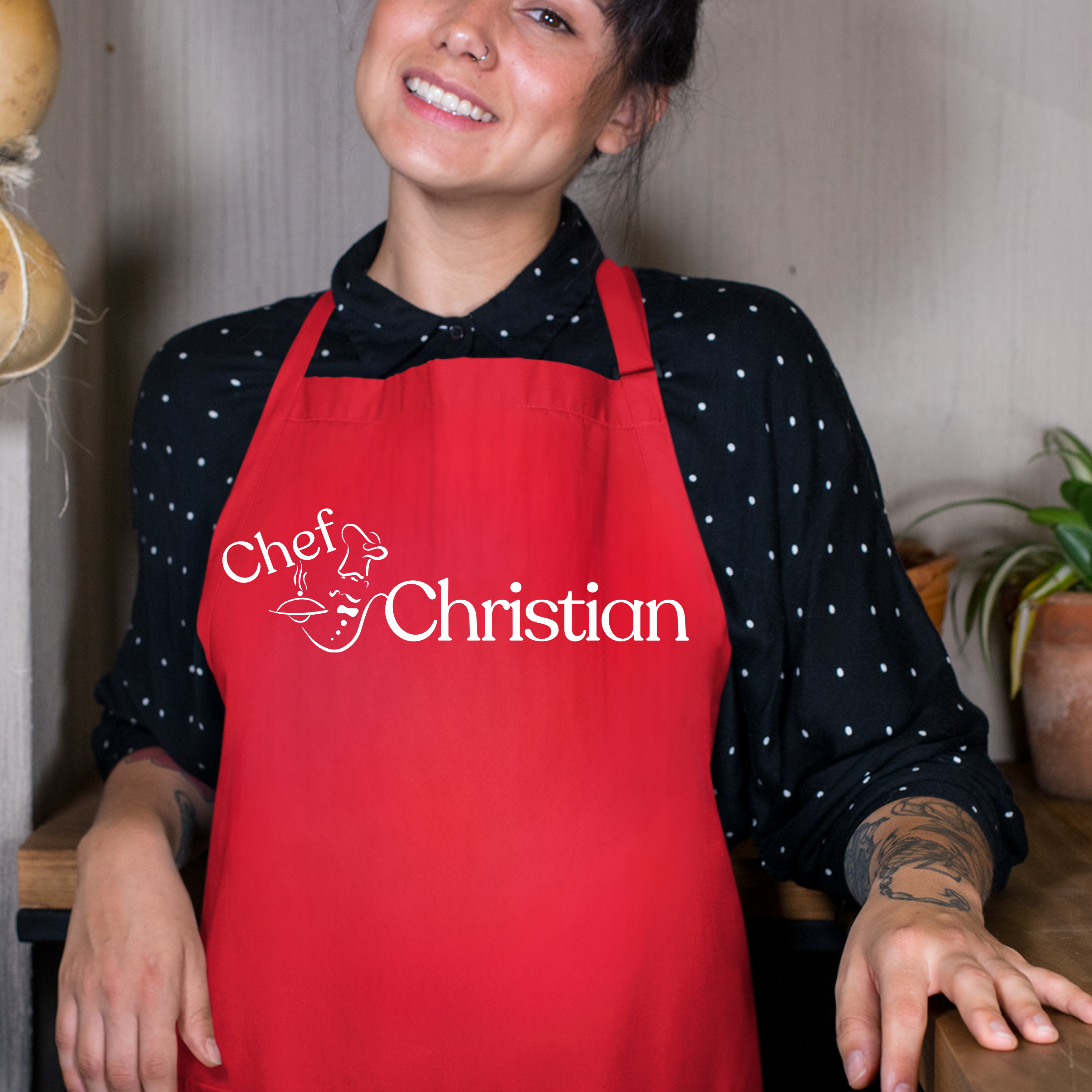 Person wearing a vibrant red apron with 'Chef Christian' text in a kitchen setting
