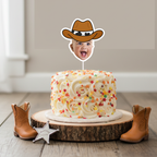 Personalized cowboy baby face cake topper displayed on buttercream smash cake with colorful star sprinkles, styled with mini cowboy boots and sheriff badge on rustic wood base. Perfect for cowboy first birthday photos, rodeo themed celebrations, wild west baby parties, and country western milestone décor. Custom baby photo cake decoration.