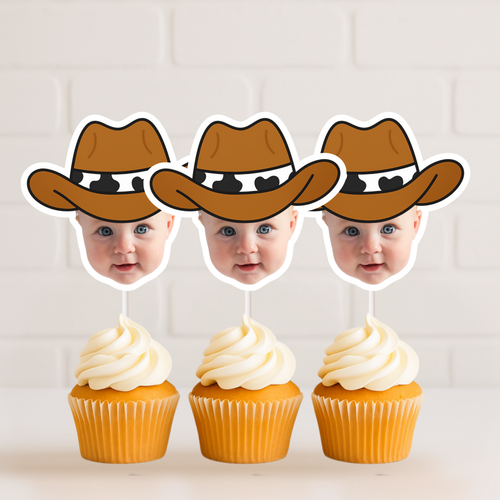 Set of three personalized cowboy baby face cupcake toppers displayed on vanilla cupcakes with white frosting against white brick background. Perfect for cowboy first birthday celebrations, wild west baby parties, and rodeo themed dessert tables. Custom child photo cupcake picks featuring brown cowboy hat design.