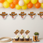 Western party scene with personalized cowboy baby face cupcake toppers on cake stand beneath matching photo banner and orange, yellow, and white balloon garland. Styled with toy horses and rope for cowboy first birthday, rodeo themed baby shower, and wild west celebration décor. Custom photo cupcake decorations.