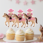 Three personalized cowgirl horse photo cupcake toppers displayed on vanilla cupcakes with white frosting and pastel sprinkles. Each topper features a smiling baby’s face on a cartoon cowgirl wearing a pink western hat, cow-print shirt, pink bandana sleeves, black pants, and pink boots while riding a tan horse with a pink saddle. The cupcakes sit on a white cake stand against a soft pink western party background with star garland and a decorative horse saddle.