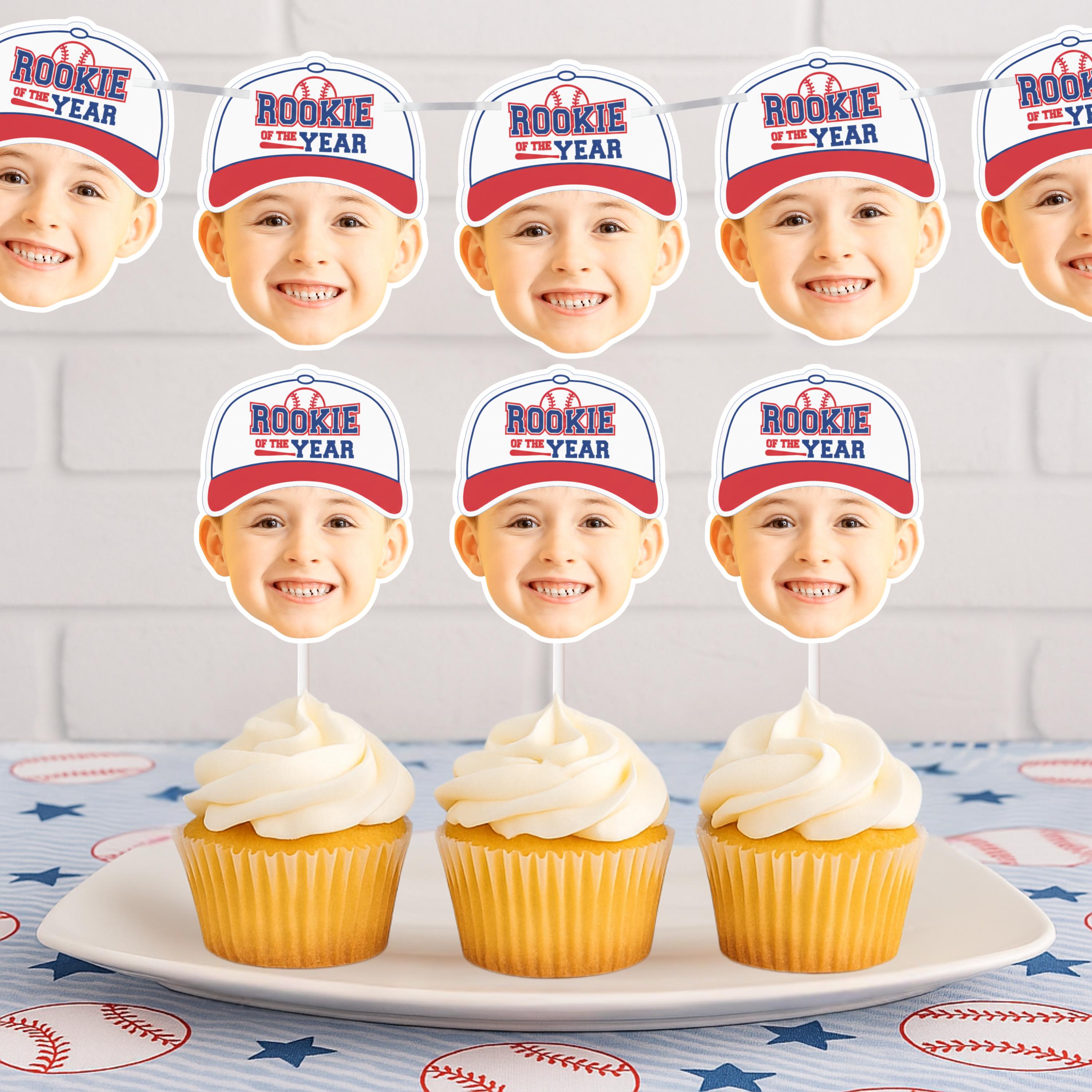 Cupcakes with 'Rookie of the Year' hats on a plate against a white brick wall background with a banner. 