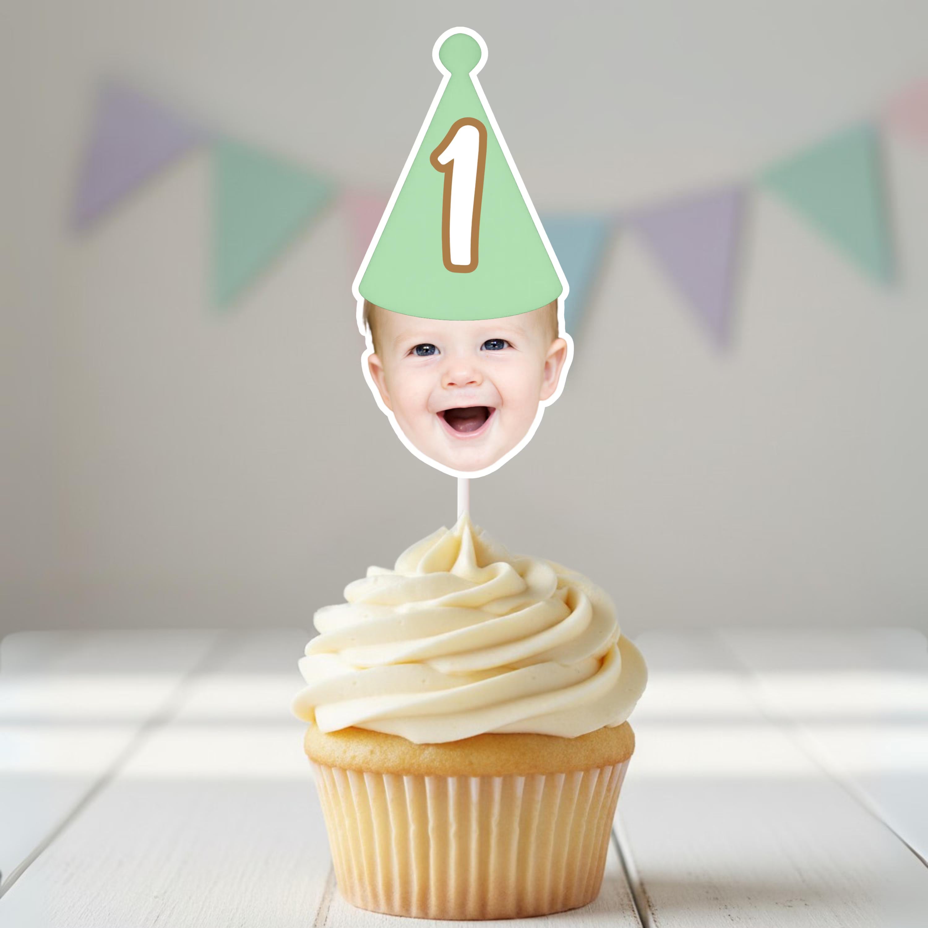 Cupcake with a birthday hat and number 1 on top, against a light background with colorful flags.