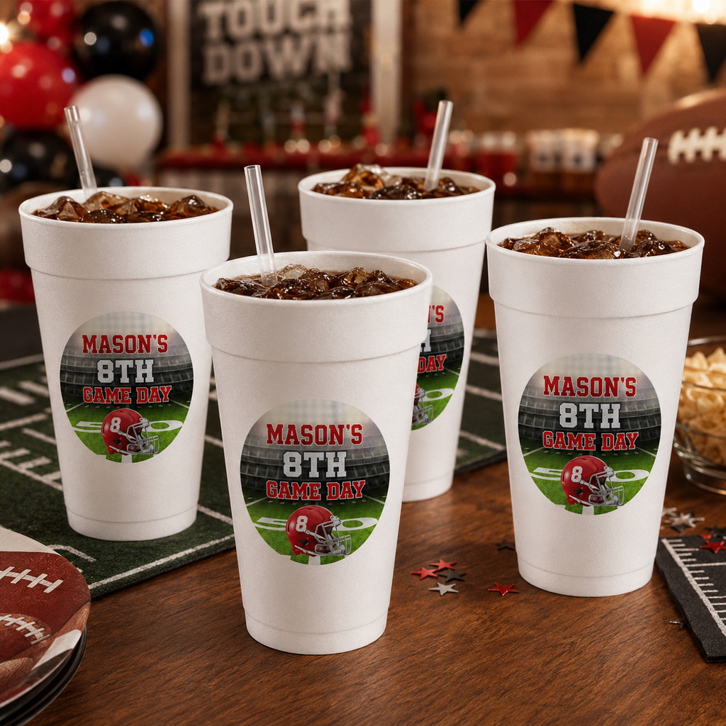 Personalized football foam cups filled with game day drinks at a family watch party with football playing on television.