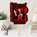 Red and black personalized graduation fan featuring a senior photo, Class of 2026 text, and custom graduate name. Boutique style graduation cheering fan perfect for graduation ceremonies, senior night celebrations, and graduation party decorations. Graduation-themed cutout with 'Congrats Class of 2023 Jessica' text and a person holding a diploma.
