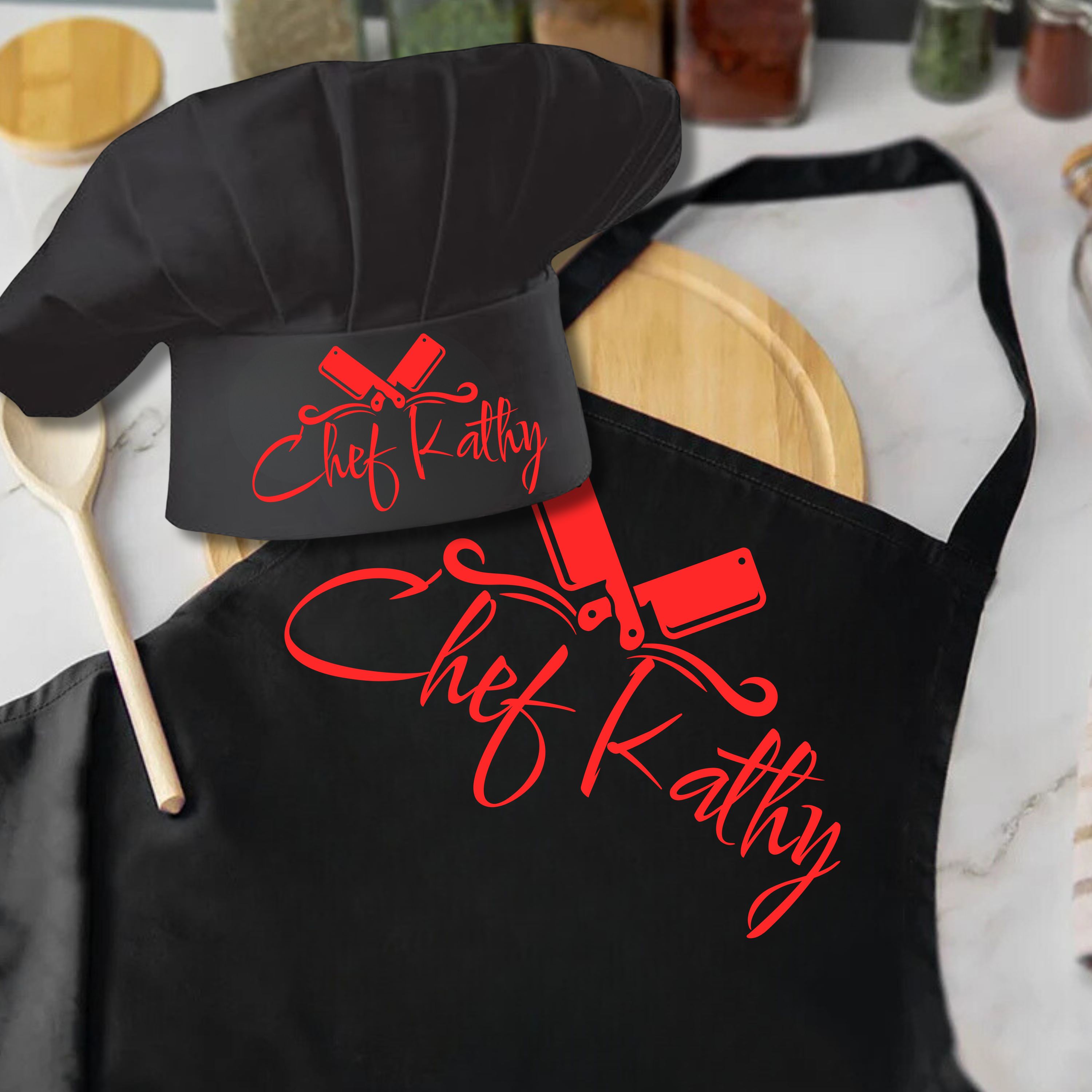 Black apron and chef hat with 'Chef Kathy' text on a kitchen counter.