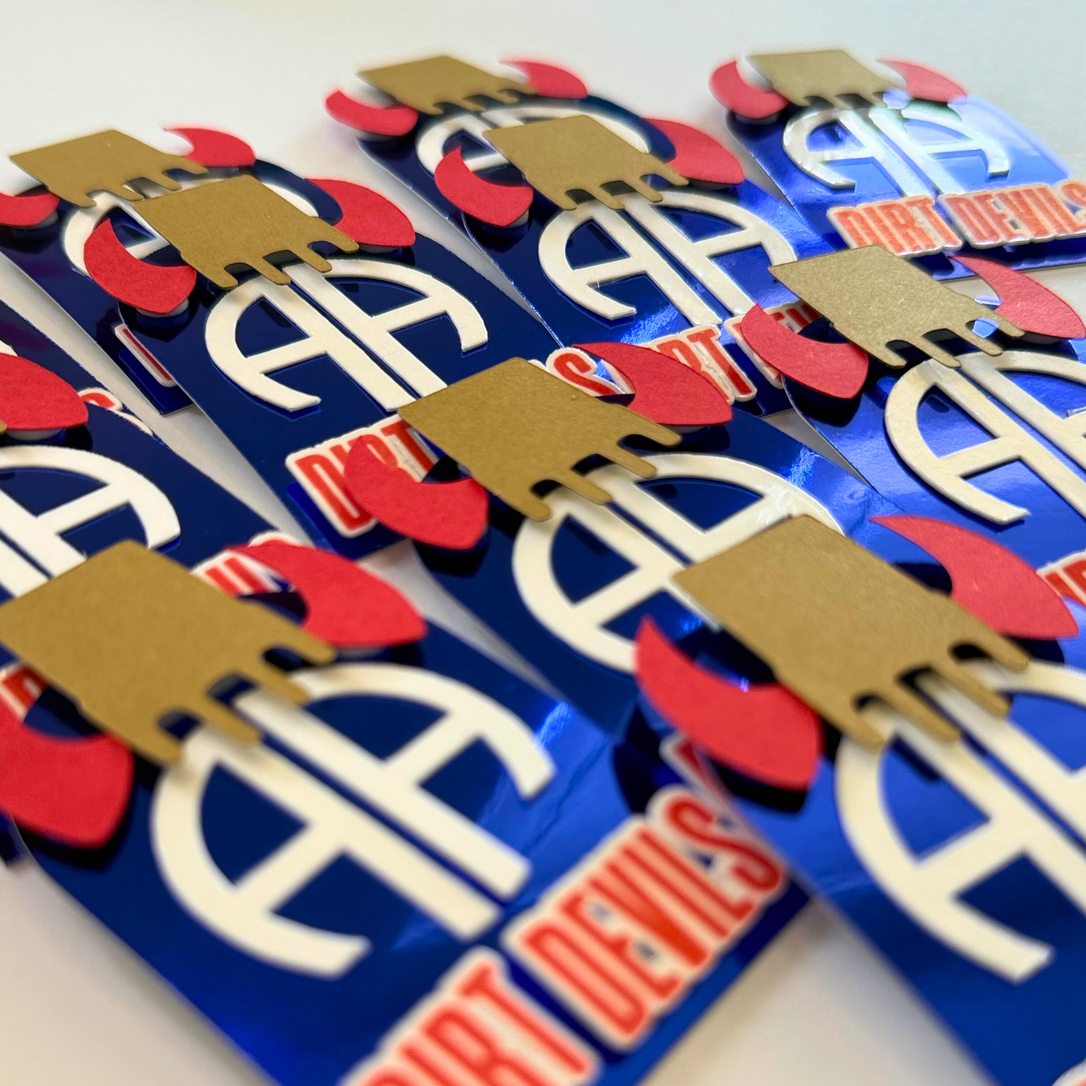 Close-up of a package with a logo and text on a white background. Handcrafted 3D layered cupcake toppers