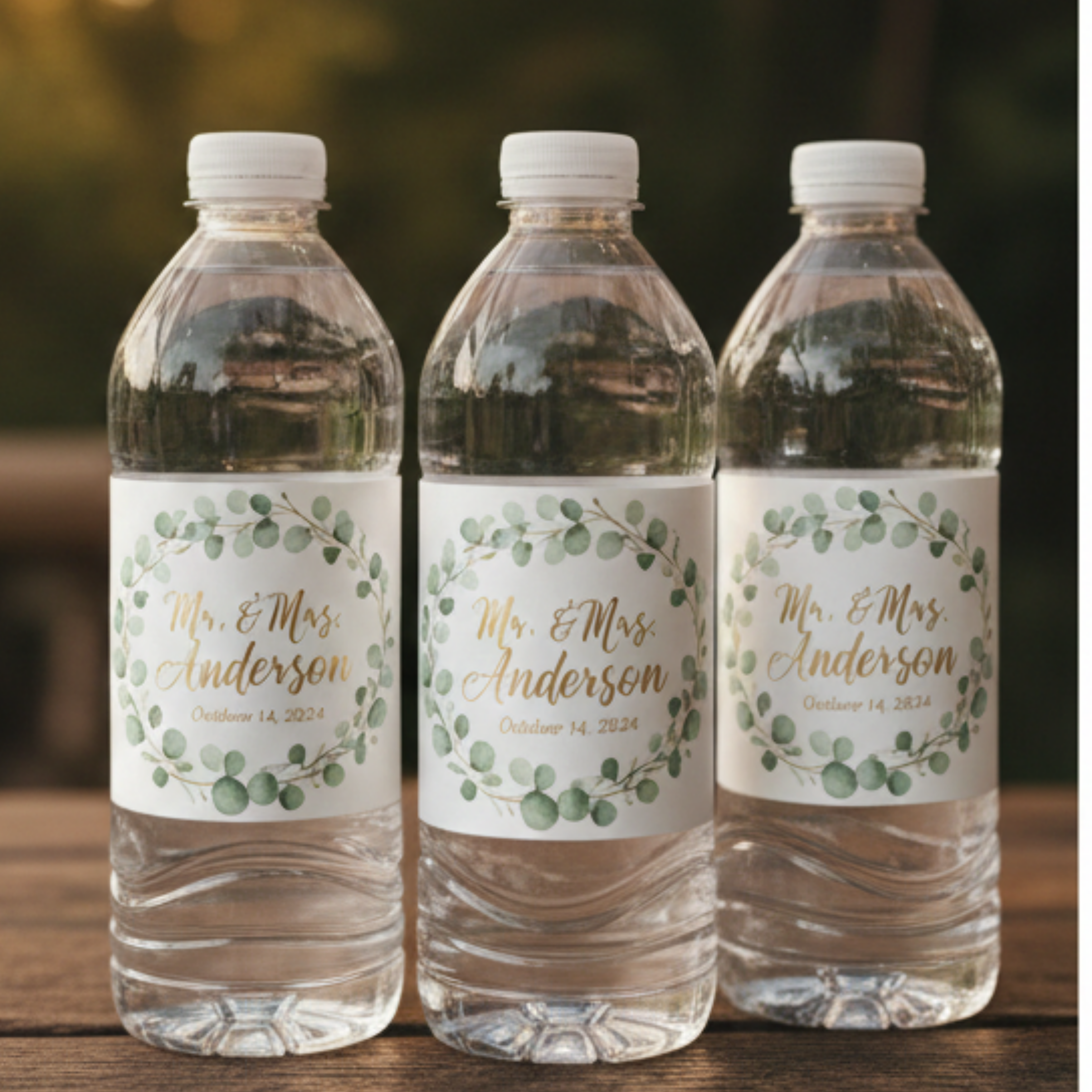 Three water bottles with personalized wedding labels on a wooden surface.