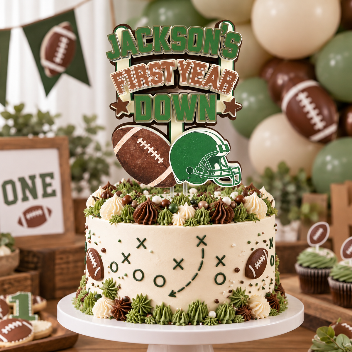 Personalized First Year Down football cake topper styled on a first birthday cake with green brown and cream balloons and football party decorations