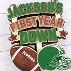 Detailed close up of layered cardstock First Year Down football cake topper showing dimensional lettering football helmet and handcrafted construction