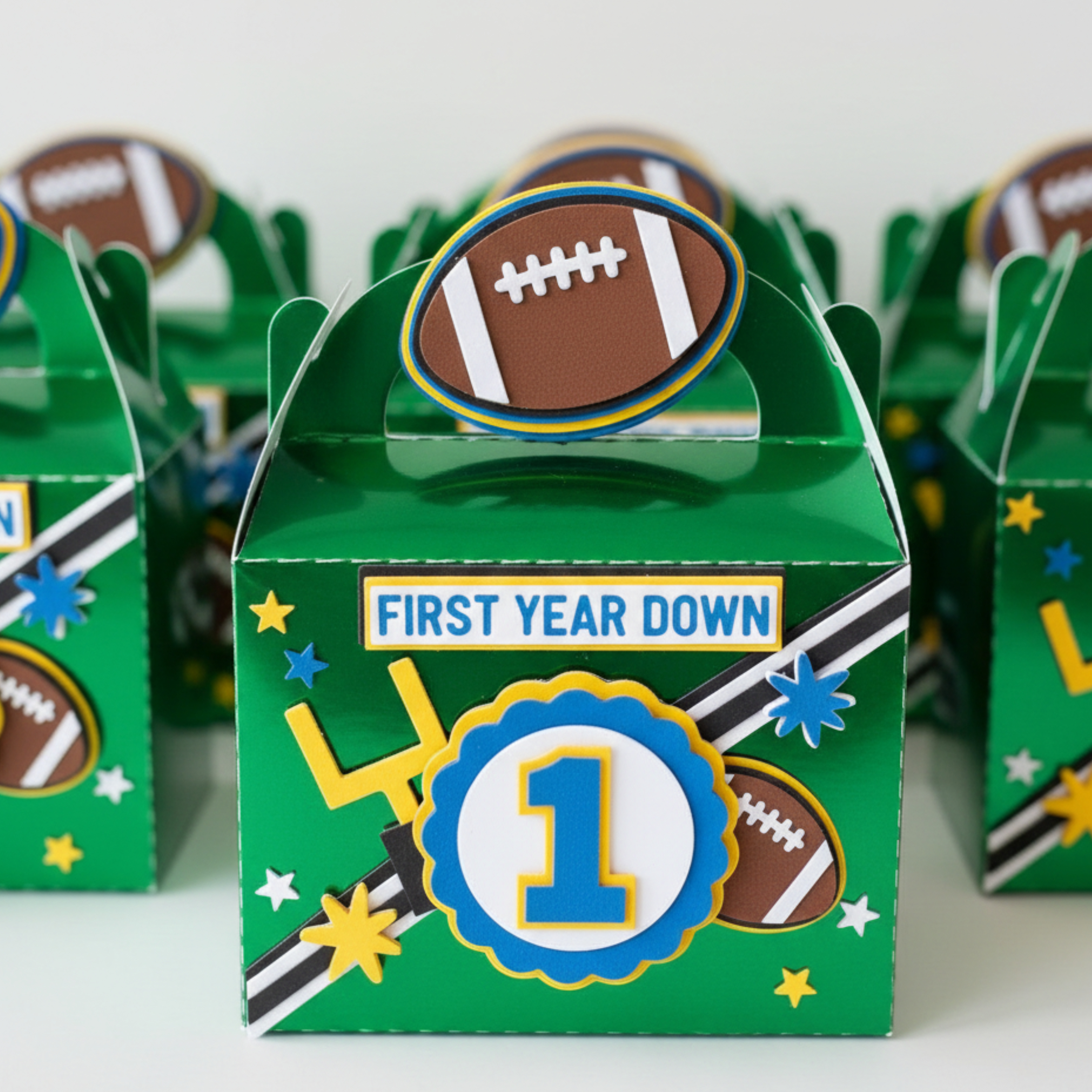 Green gift box with football design and 'First Year Down' text, surrounded by similar boxes.