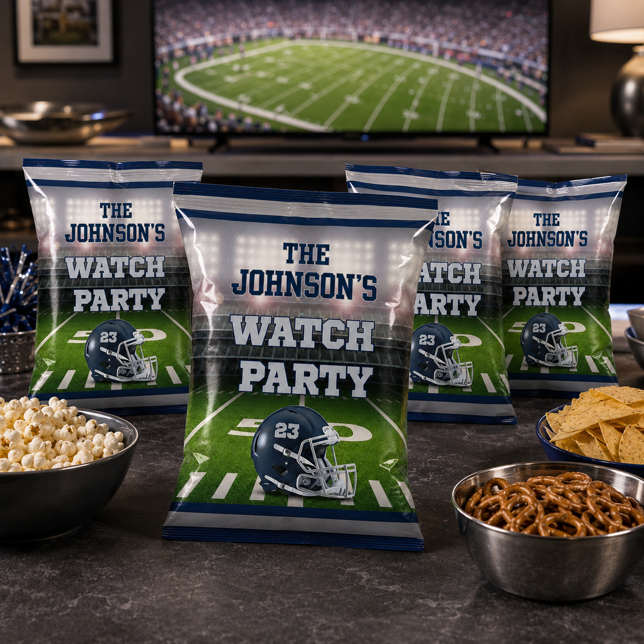 Navy and silver personalized football chip bags arranged with popcorn pretzels and chips for an adult game day watch party.