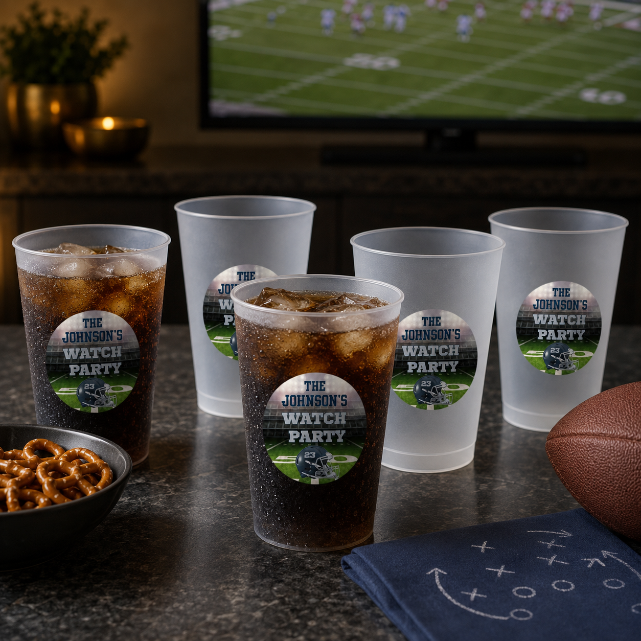 Personalized 16 oz frosted football flex cups arranged with cold drinks for an adult watch party