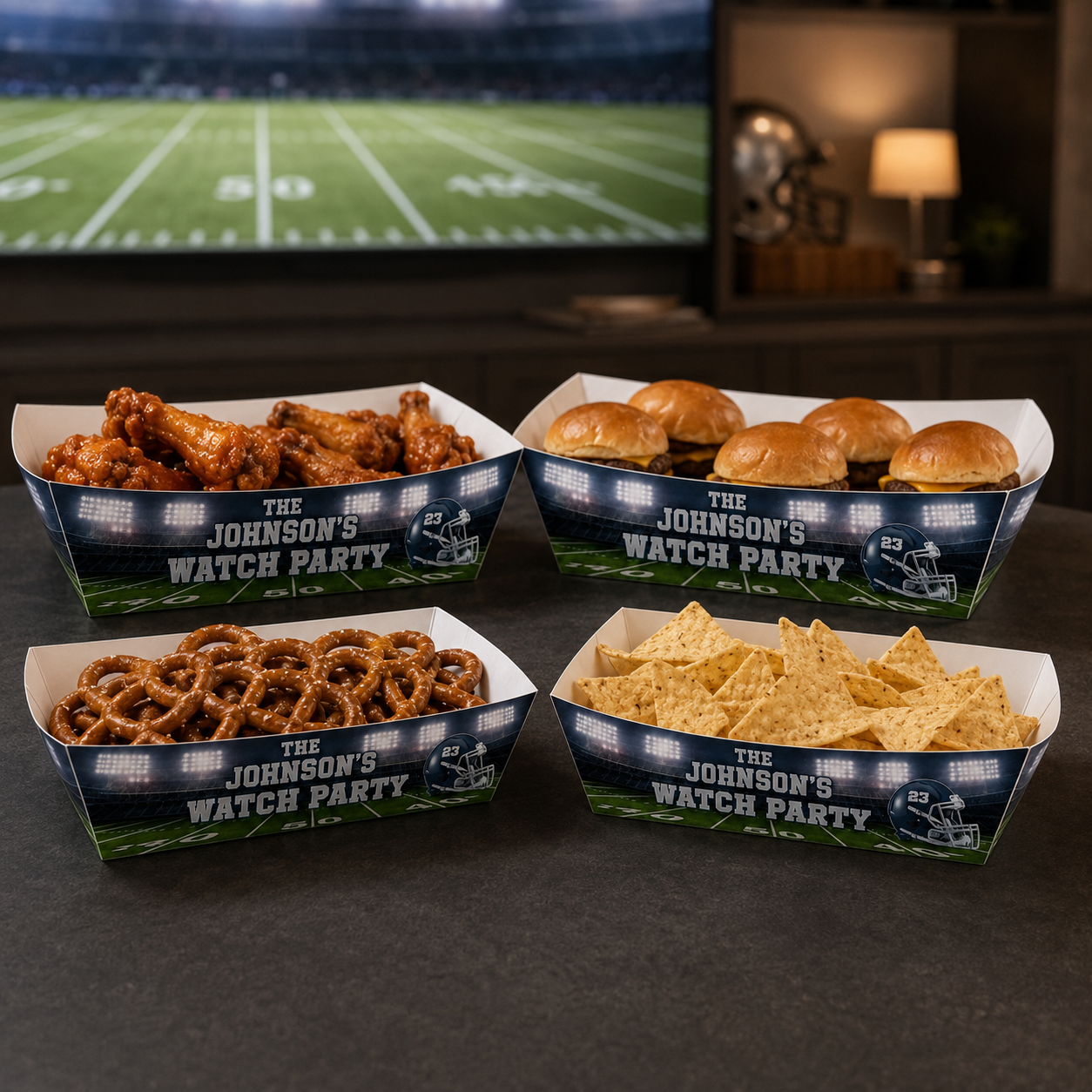 Navy and silver personalized football food trays filled with wings, sliders, pretzels and tortilla chips for an adult game day watch party.