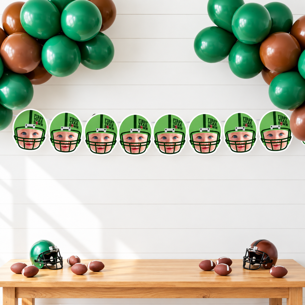 Personalized First Year Down football photo banner featuring eight child face panels in green football helmets displayed with green and brown balloons for a football first birthday party