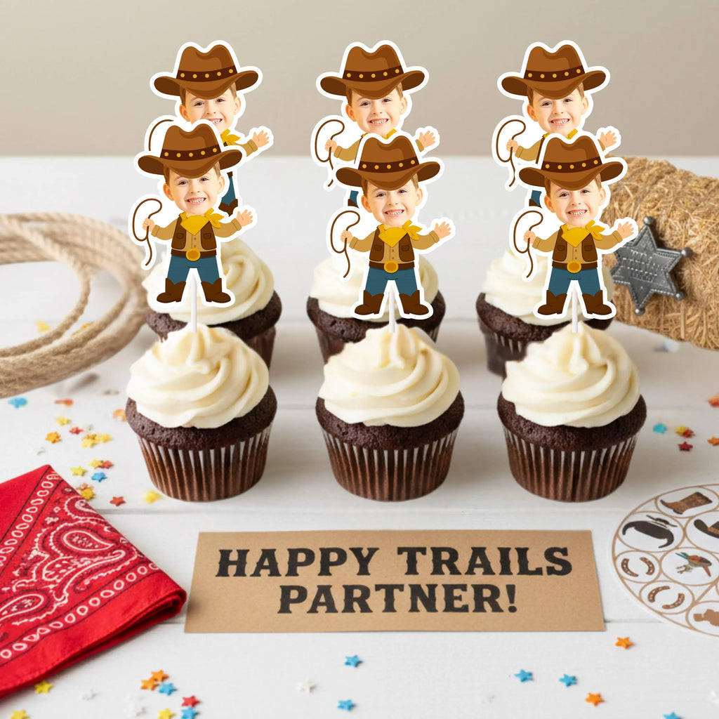 Cupcakes with cowboy-themed toppers on a table with 'Happy Trails Partner!' sign.