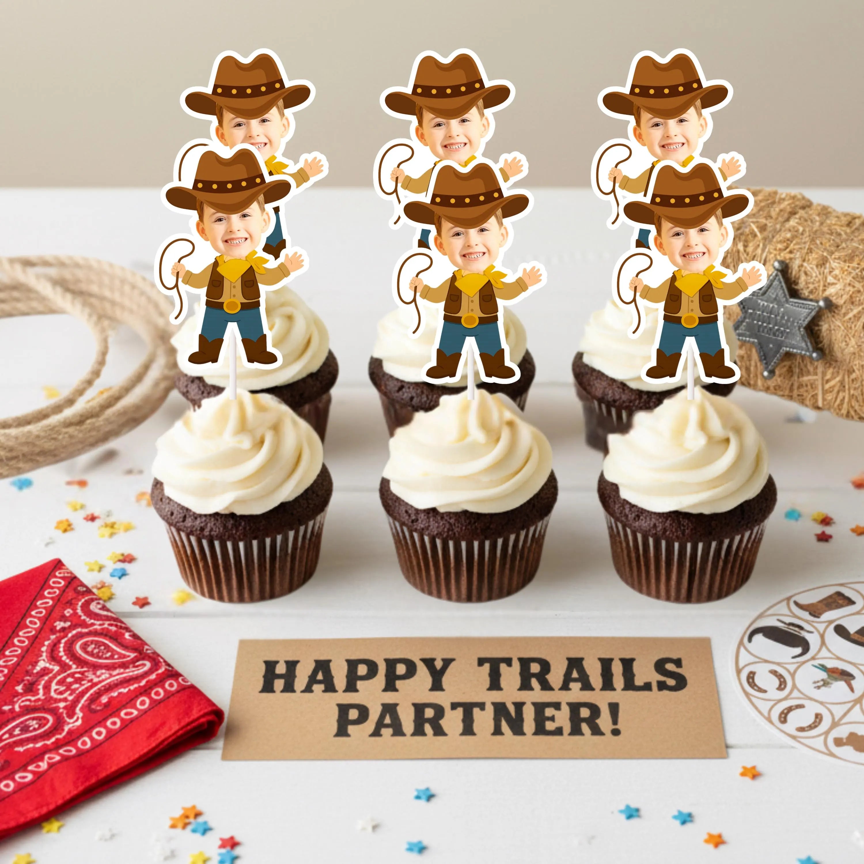 Cupcakes with cowboy-themed toppers on a table with 'Happy Trails Partner!' sign.