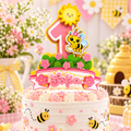 Honey bee birthday cake topper on a decorated cake with daisies flowers pastel pink accents and personalized first birthday design