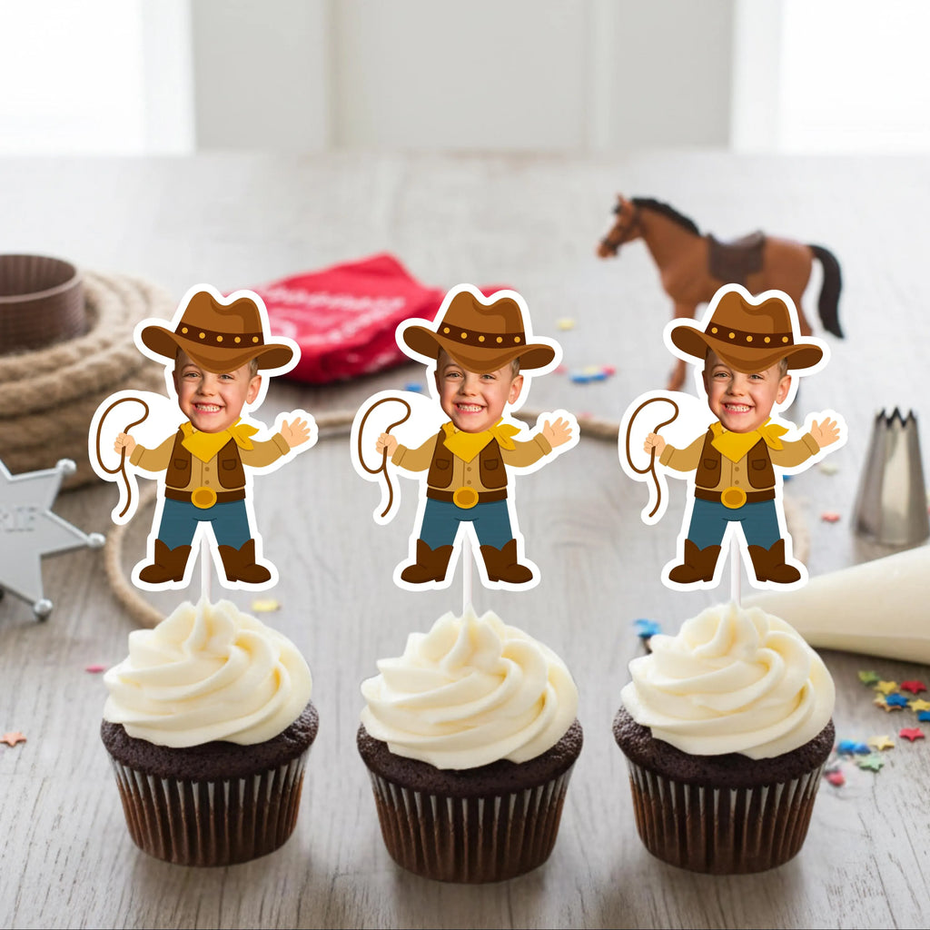 Three cupcakes with cowboy-themed toppers on a wooden surface.
