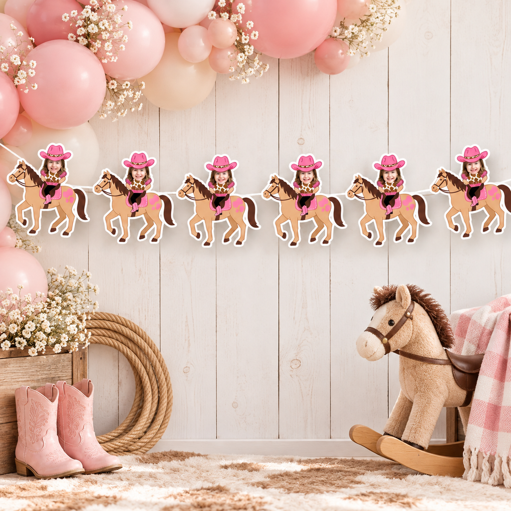 Personalized My First Rodeo cowgirl photo banner displayed with pink and cream balloons hay bale rope bandana and western party decorations for a little cowgirl birthday