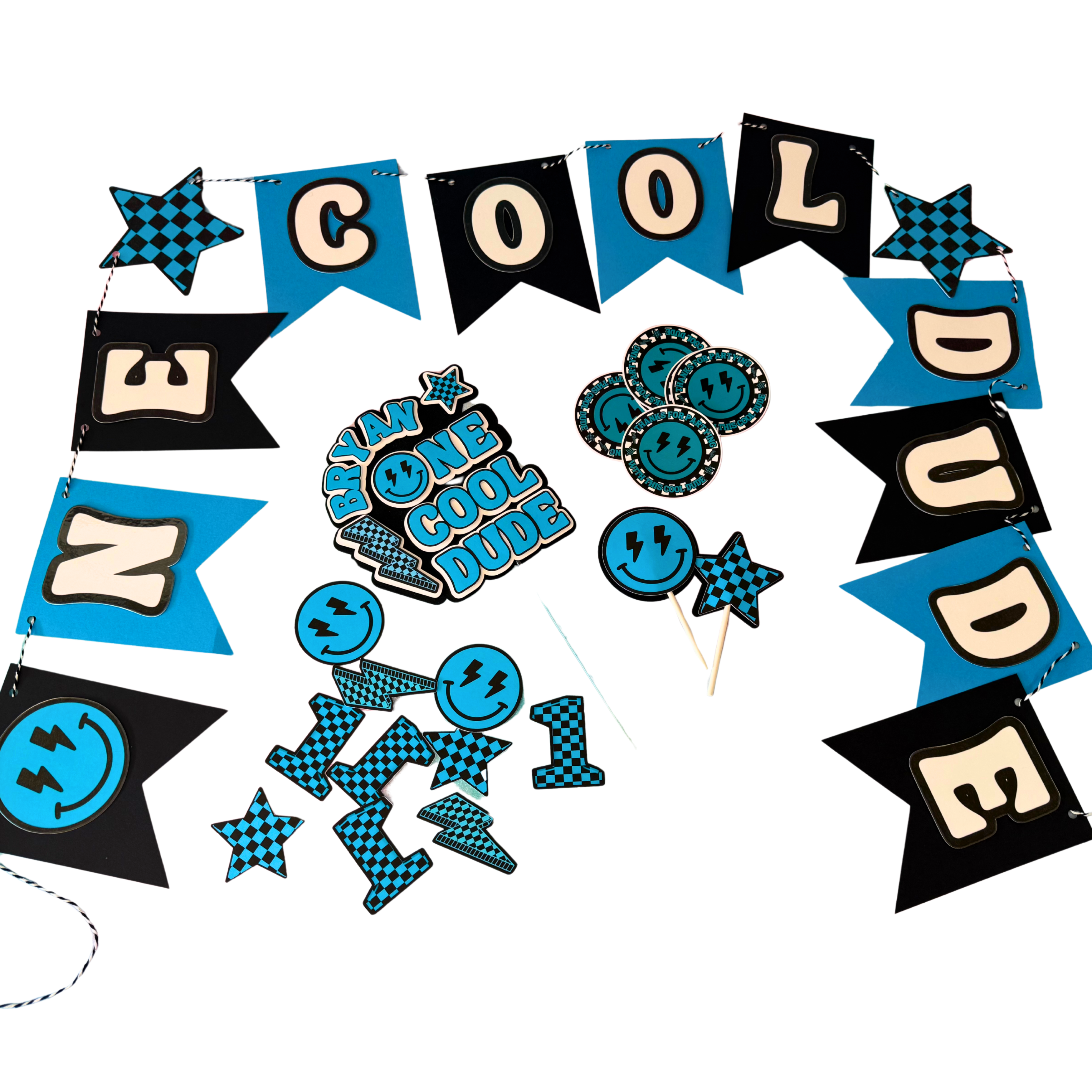 Decorative party kit with 'One Cool Dude' banners, single layer cake topper, cupcake toppers, stickers and confetti on a white background