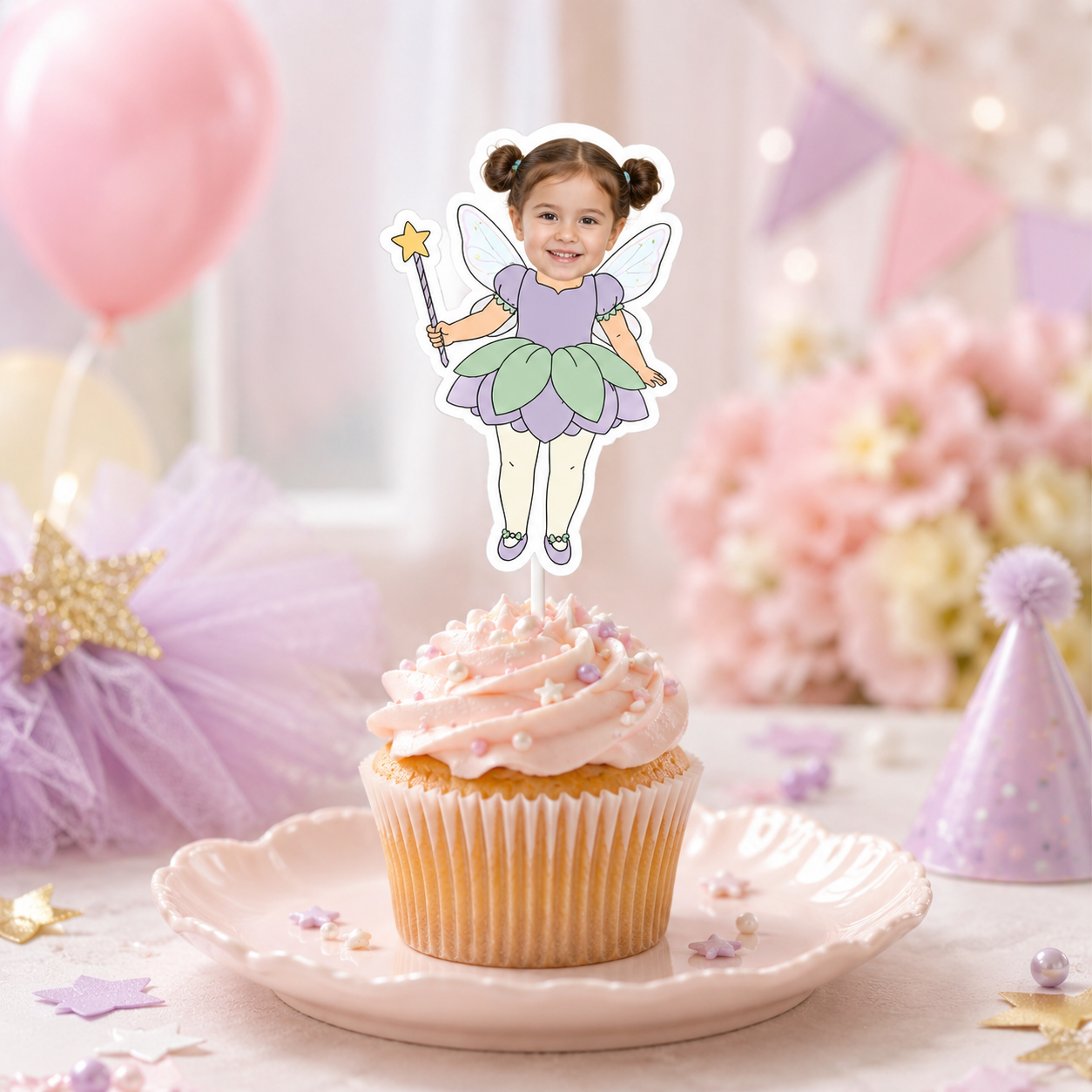 Single personalized fairy photo cupcake topper featuring a smiling child with translucent wings a lavender top green and purple flower petal skirt and golden star wand displayed on a pink frosted cupcake for a magical fairy birthday party