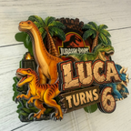 Personalized sixth birthday dinosaur cake topper for Luca featuring Jurassic Park inspired jungle scenery palm trees velociraptor long neck dinosaur triceratops and layered number six details