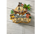 Full view of personalized pirate birthday cake topper with layered pirate ship treasure chest palm tree custom name age and clear cake picks.