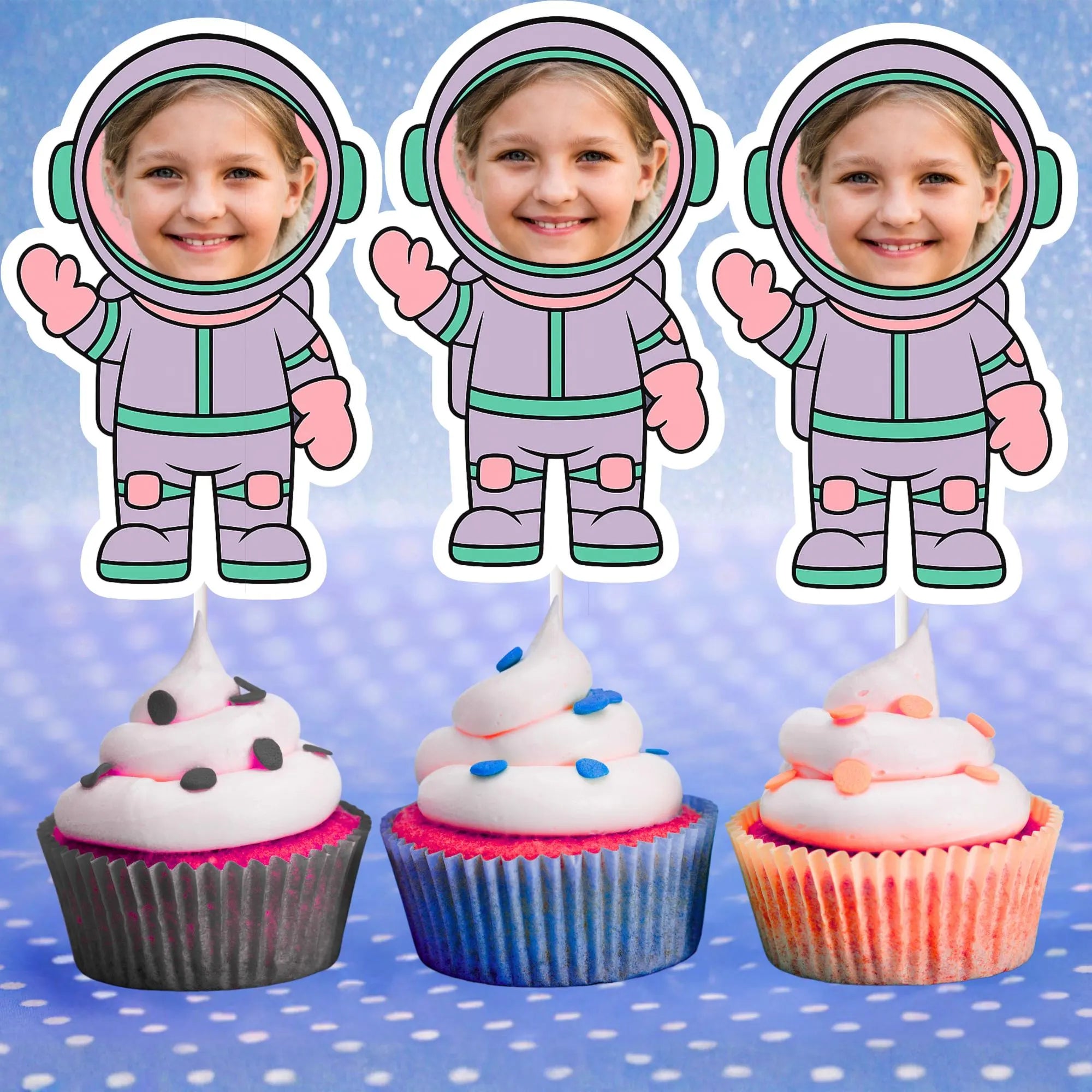 Three cupcake toppers with a child in an astronaut suit on a blue polka dot background.