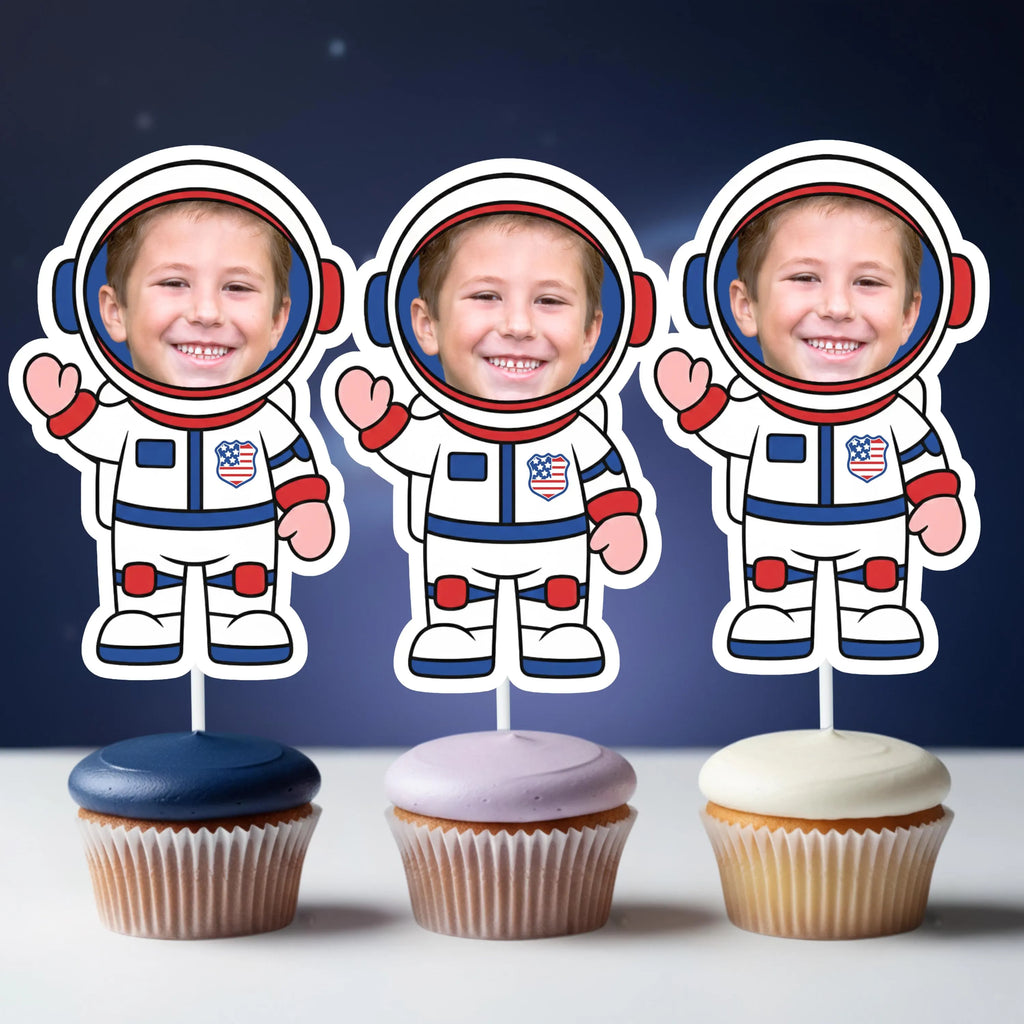 Three cupcakes with astronaut toppers on a dark blue background