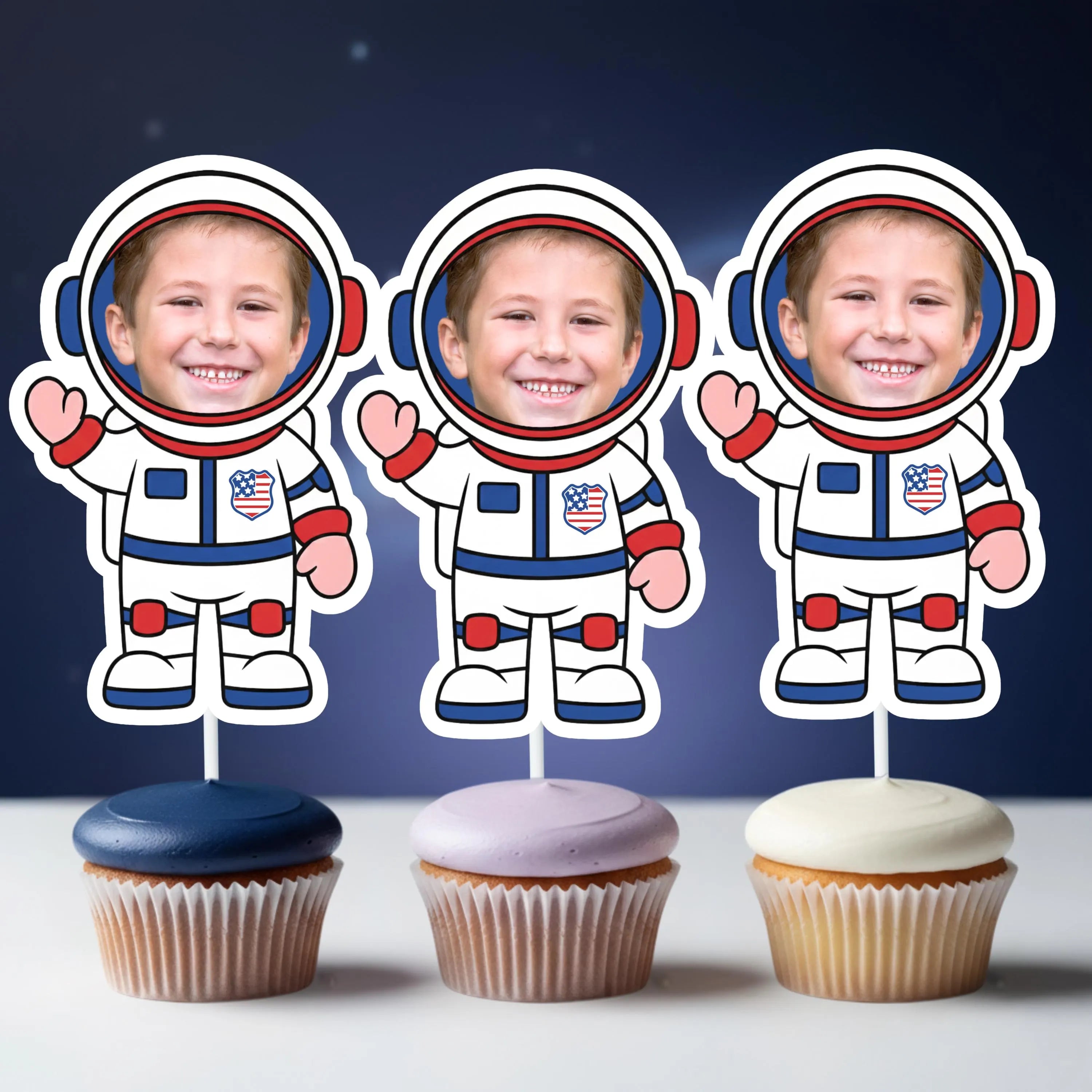 Three cupcakes with astronaut toppers on a dark blue background