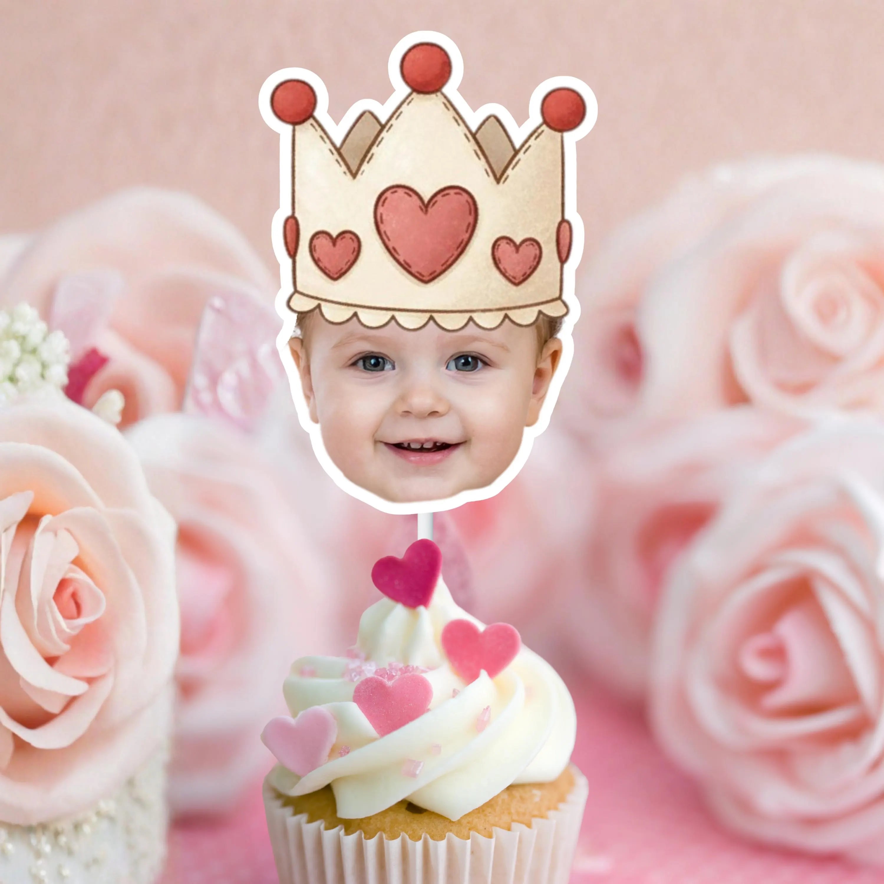 Baby with a crown made of hearts on a cupcake against a pink rose background
