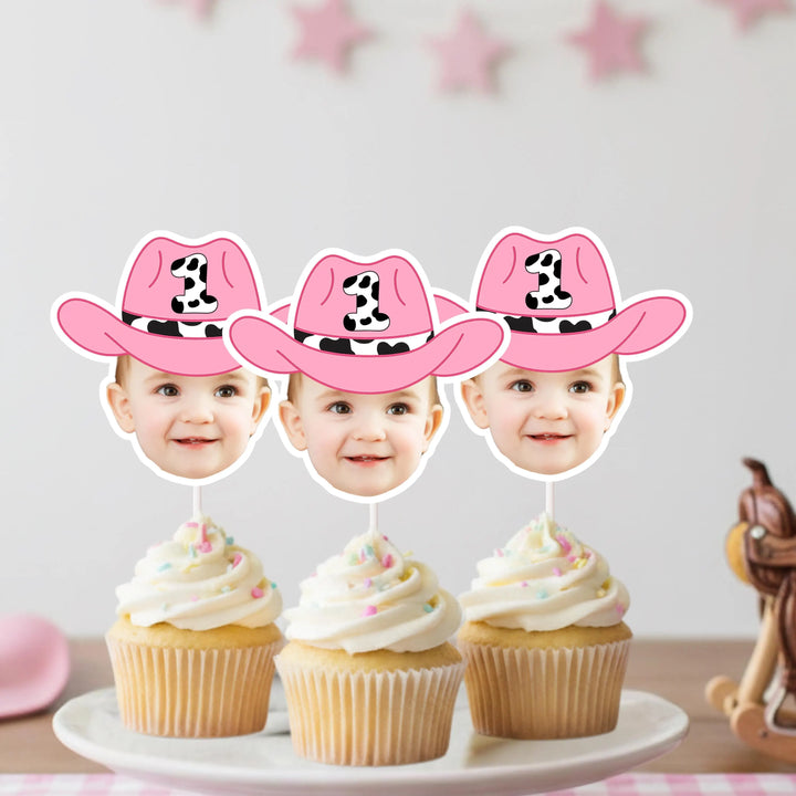 Three cupcakes with pink cowboy hats on top, featuring cutouts of children's faces.
