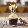 Personalized cowboy face cupcake topper featuring a child’s photo on a cartoon western body, standing upright in white buttercream frosting on a chocolate cupcake for a wild west themed birthday party.