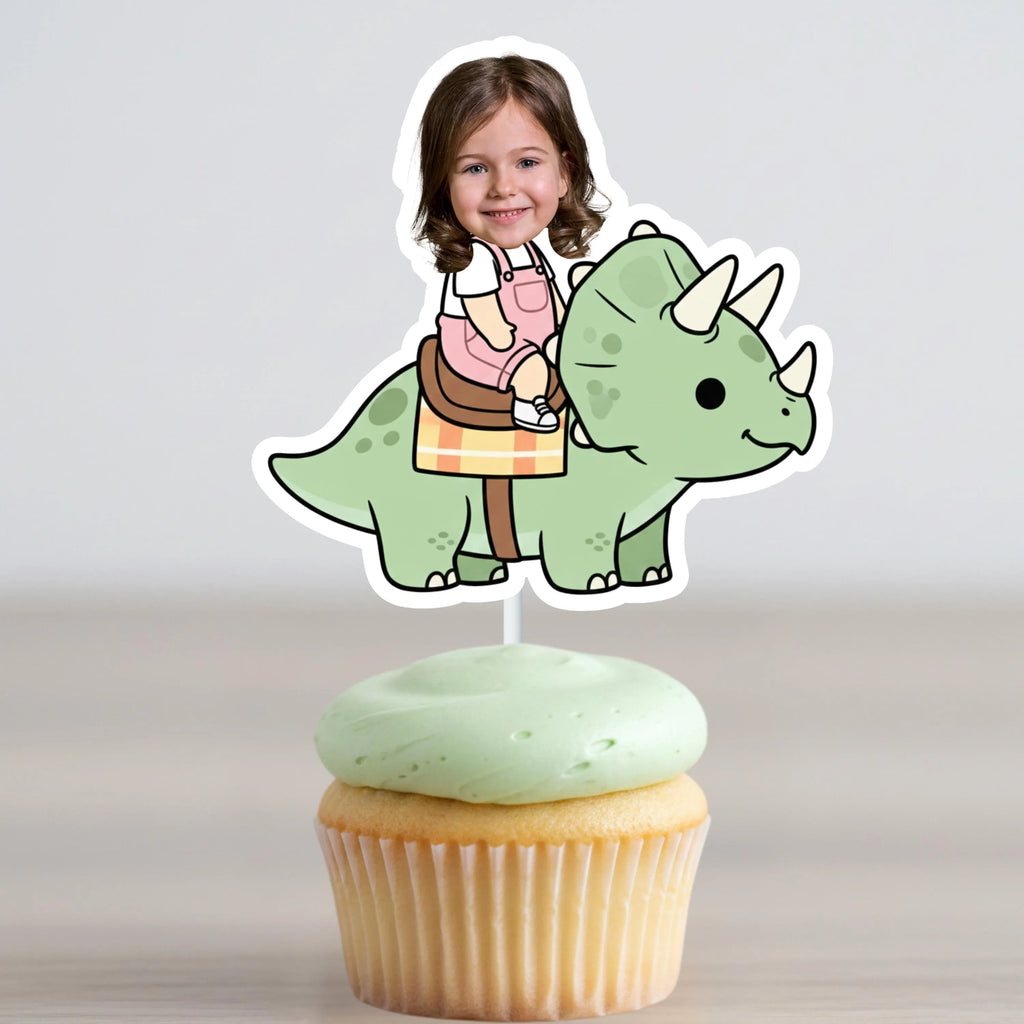 Cupcake with a dinosaur topper featuring a child's photo on a plain background