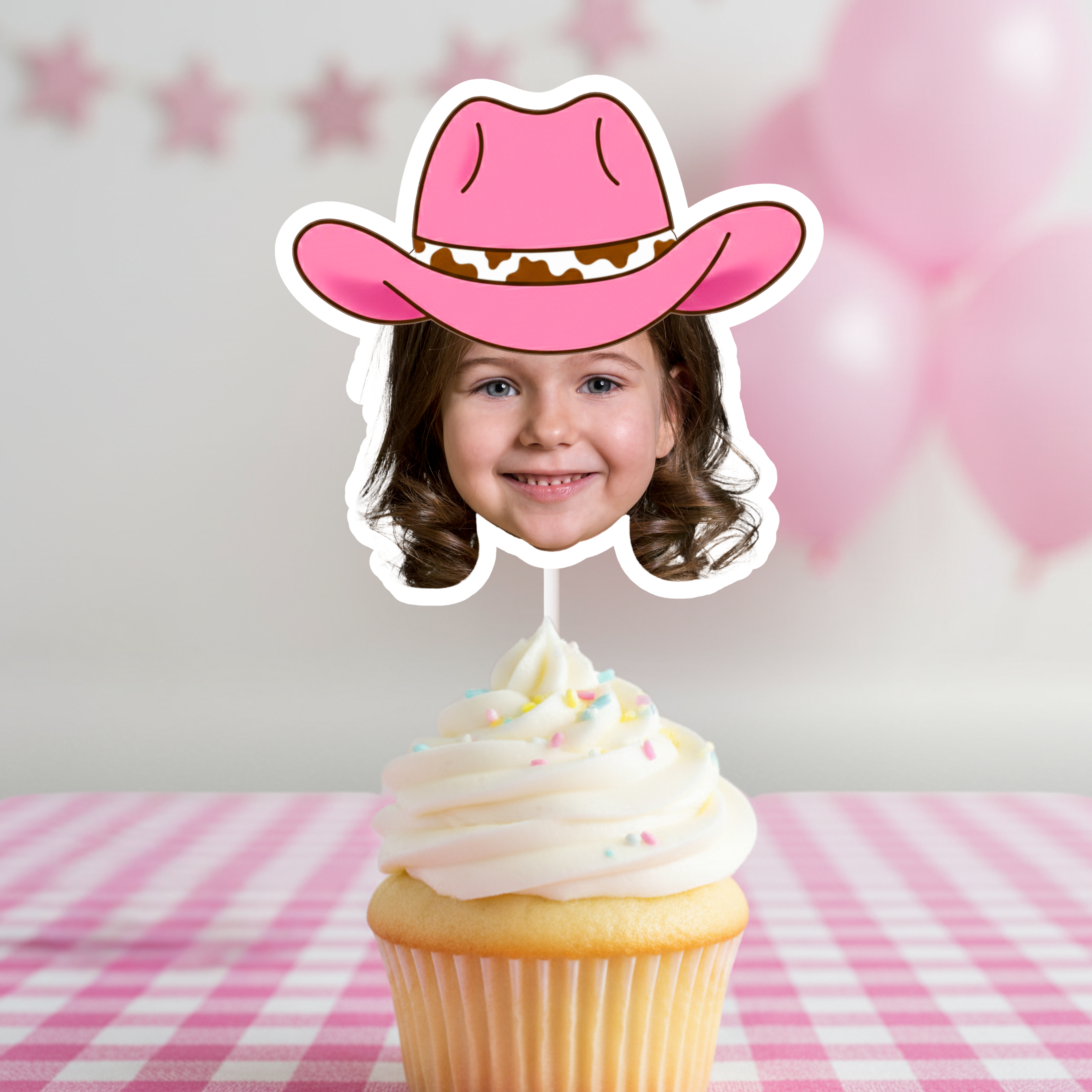 Close up of a personalized pink cowgirl hat photo cupcake topper styled on a frosted vanilla cupcake with soft pink birthday decor. Custom face cupcake topper ideal for My First Rodeo celebrations, cowgirl first birthday parties, pony themed events, and western girl birthday dessert tables. A sweet and playful rodeo party decoration designed to highlight your child’s photo in a pink country theme.